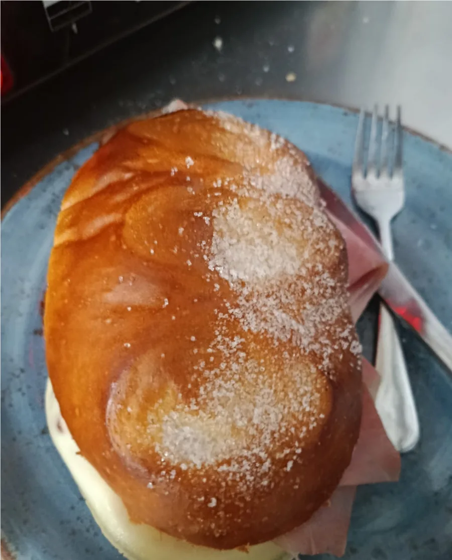 Bollo azucarado con jamón y queso fundido